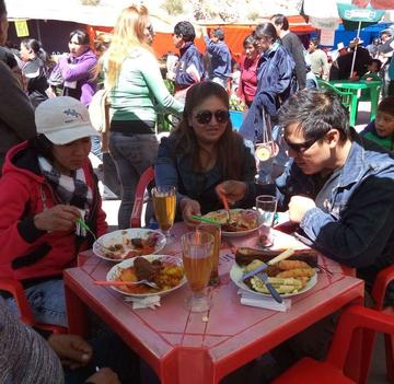 Los comensales con los platos típicos y el refresco de mocochinchi.