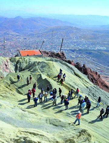 Los visitantes en la cumbre del coloso y al fondo la ciudad de Potosí.