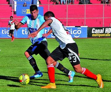 El delantero de la banda roja, Tommy Tobar lucha por el balón con su rival.