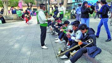 Los integrantes de una banda musical se sirven sus alimentos en la plaza San Bernardo.