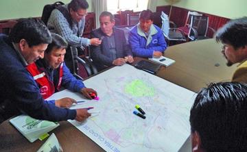El gobernador y el alcalde revisan el plano de la ciudad.