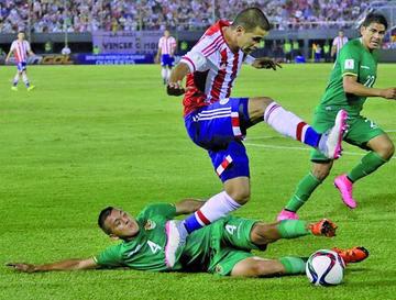 Jorge Flores (abajo) disputa el balón con el paraguayo Derlis González.