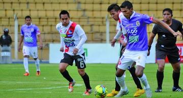 Gilbert Álvarez trata de pasar la marca de los zagueros de la banda roja.