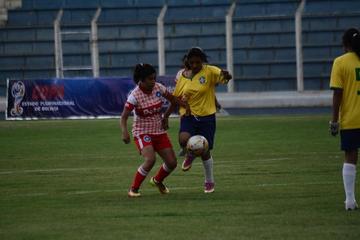 Las futbolistas de Potosí (d) intenta quitar el esférico.