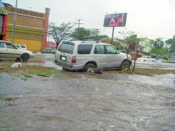 Un vehículo afectado por las corrientes de agua, en una de las calles de la ciudad de Santa Cruz.