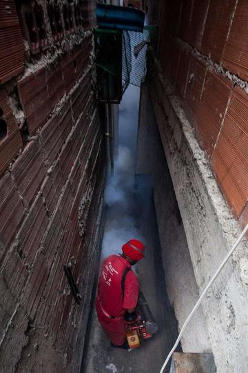 Un trabajador de la Alcaldía de Libertador de Caracas fumiga zonas de riesgo.