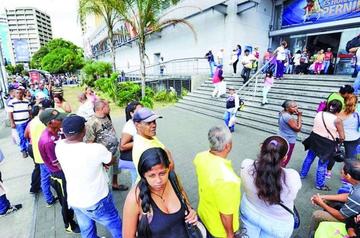 Decenas de personas tienen que hacer largas filas en afueras de los supermercados venezolanos.