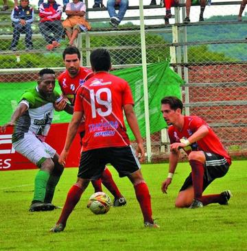 Los futbolistas de la banda roja marcan a uno de sus rivales.