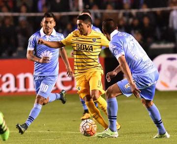 El jugador Rudy Cardozo (i) y Ronald Eguino disputan el balón con Federico Carrizo.