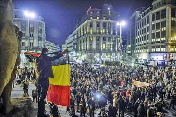 Varias personas protestan en la plaza Bourse de Bruselas, tras las tres explosiones.