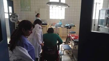 Una mujer es ingresada en silla de ruedas a la sala de partos.