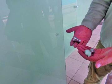 Uno de los encargados muestra las manijas rotas de las puertas.