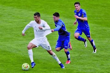 El delantero del Real, Cristiano Ronaldo (i), es perseguido por su rival, Moi Gómez.