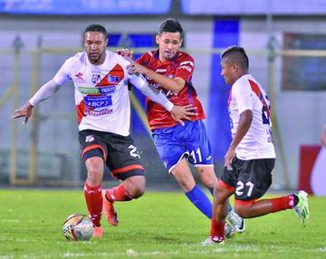 Tommy Tobar, de Nacional, protege el esférico de su rival.