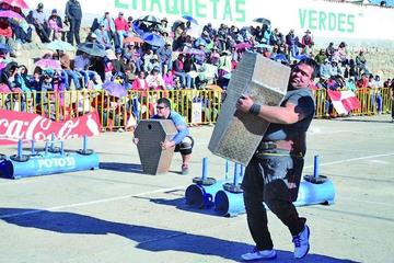 Los atletas en la prueba del paseo del granjero y el escudo.