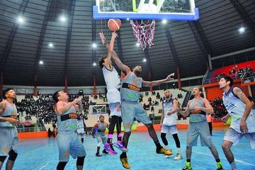 El basquetbolista David Oros, de Calero, intenta encestar la pelota ante la marca de un rival.