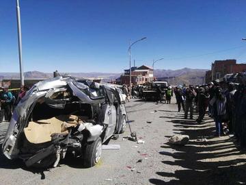 Vista del área del accidente con un vehículo pequeño completamente destrozado.