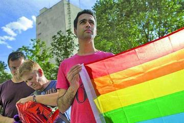 Un joven en Madrid sostiene una bandera del arcoíris durante una concentración de apoyo a la comunidad LGTB.