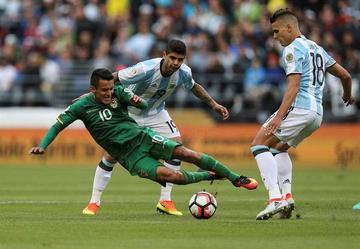 Jhasmani Campos (i) cae ante la marca de los argentinos Ever Banega (atrás) y Erik Lamela (d).
