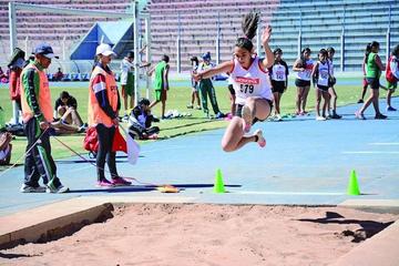 Una de las deportistas en pleno salto largo.