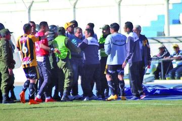 El DT de The Strongest, Oscar Luna es sacado de la cancha por policias.