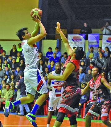Cristian Camargo, de San Simón, trata de encestar el balón ante la marca de René Calvo, de Pichincha.