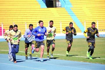 Los jugadores trotan en la pista atletica.