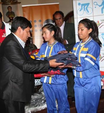 El gobernador , Juan Carlos Cejas, entrega el material a las estudiantes del Santa Rosa.