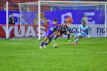 Carlos Saucedo trata de quitarse la marca de Edemir Rodriguiez y el meta Diego Zamora.