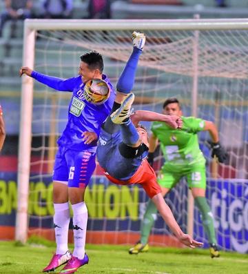 Limbert Méndez (i) despeja el balón ante la arremetida de su rival.