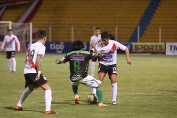 Eduardo Puna (c) quita el balón a los locales.