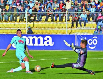 Gastón Cellerino trata de batir al meta de Petrolero, Iván Brun.
