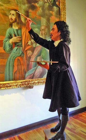 La figura delante de una de sus obras.