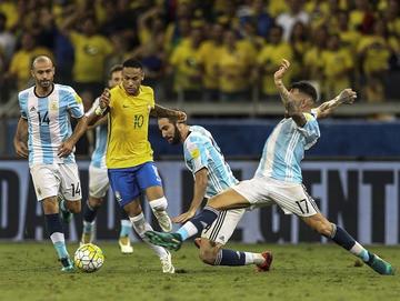 El delantero brasileño Neymar controla el balón ante la marca de sus rivales.