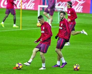El delantero de Atlético, Fernando Torres, controla el balón.