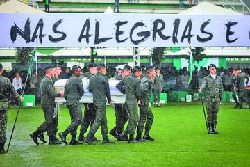 Militares brasileños cargan los féretros de los jugadores y equipo técnico del club brasileño Chapecoense durante el vel