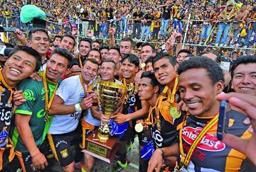 El plantel aurinegro festeja con su trofeo.