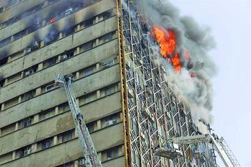 Equipos contra incendios luchan para sofocar las llamas en el edificio Plasco antes de su derrumbe