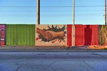 Vista de una pintada sobre la cerca fronteriza que divide al estado de Mexicali ( México) y Calexico (EE.UU.).