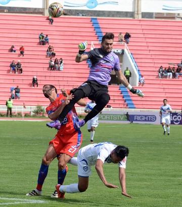 El meta Carlos Franco es derribado por su rival.