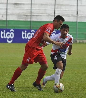 Darwin Lora, de la banda roja, intenta quitar la pelota a su rival.