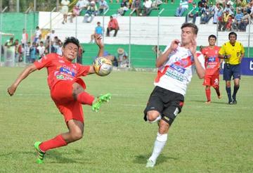 Uno de los jugadores azucareros despeja el balón ante la marca de Bruno Pascua, de Nacional.