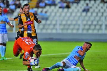 El meta daniel vaca detiene el balón ante un ataque del rival.