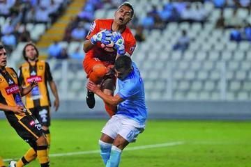 El meta daniel vaca detiene el balón ante un ataque del rival.