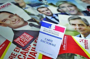 Una credencial para votar es fotografiada sobre los panfletos de los 11 candidatos para las presidenciales francesas.