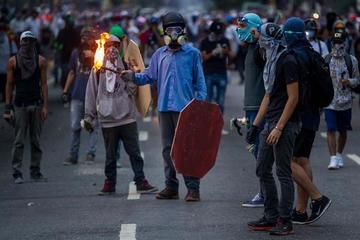 Un grupo de manifestantes se enfrenta con la Policía durante una protesta de opositores al Gobierno venezolano.