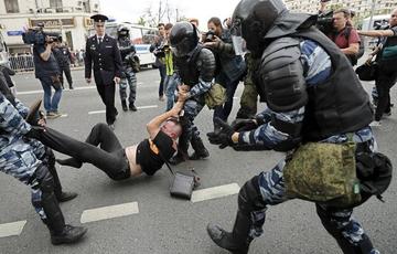 Miembros de la policía detienen a uno de los participantes de la manifestación no autorizada en la céntrica calle Tversk