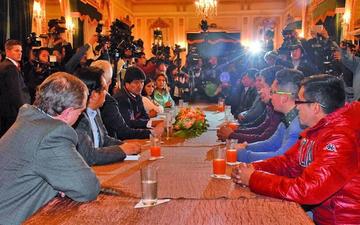 Los nueve acompañados de sus familias y funcionarios de Gobierno.