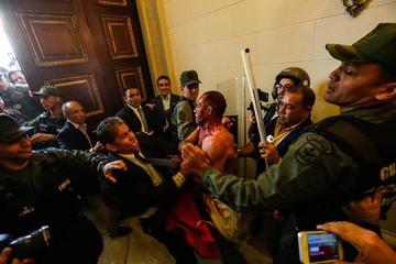 Personas forcejean durante enfrentamientos en la Asamblea Nacional.