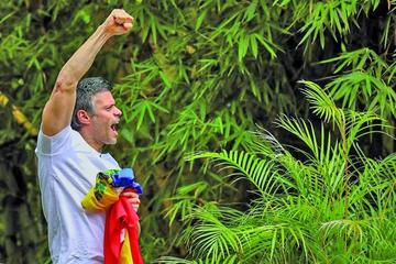 El político saluda a sus seguidores desde su casa en Caracas.